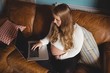 © Wavebreak Media - Pregnant woman using laptop in living room