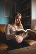 © Wavebreak Media - Pregnant woman reading book in living room