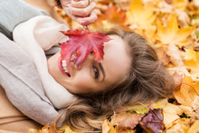 Beautiful Happy Woman Lying On Autumn Leaves