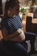© Wavebreak Media - Pregnant woman sitting on exercise ball in living room