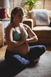 © Wavebreak Media - Pregnant woman performing yoga in living room