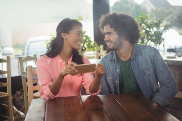 Poster - Couple looking at each other while holding mobile phone