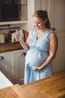 © Wavebreak Media - Pregnant woman drinking water in kitchen