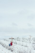 Una persona visitando un cementerio vacío lleno de nieve en invierno 