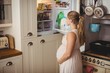 © Wavebreak Media - Pregnant woman looking for food in refrigerator in kitchen