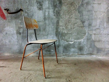 Old Chair Lonely Resting In Front Of Concrete Wall