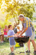 © luckybusiness - smiling grandfather and grandson at barbecue.