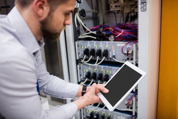 Fototapete - Technician using digital tablet while analyzing server