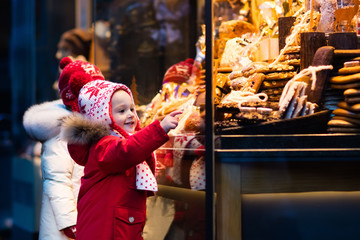 Wall Mural - Kids looking at candy and pastry on Christmas market