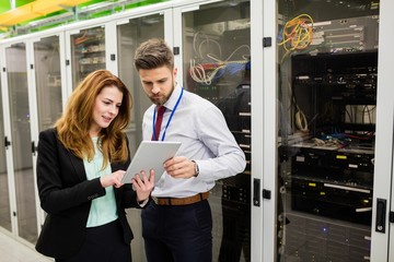 Fototapete - Technicians using digital tablet while analyzing server