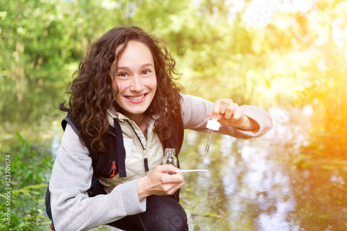 Fotomural Young attractive biologist woman working on water analysis