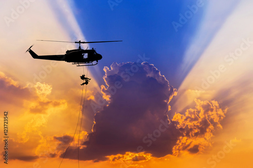 Zdjęcie XXL sylwetka żołnierzy w akcji rappelling zejść z helikoptera z misji wojskowej counter terroryzm szkolenia szturmowe na zachód słońca