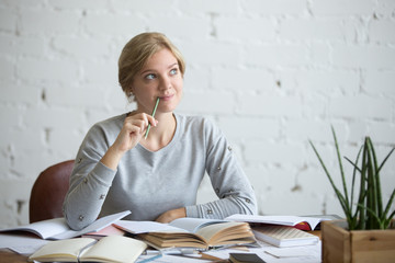 Portrait of a dreaming student woman sitting at the desk, head in the clouds, lifestyle. Education concept photo