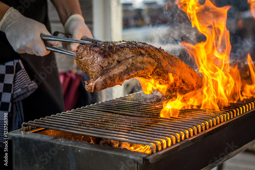 Fotografía Grilling entrecote on a barbecue with fire