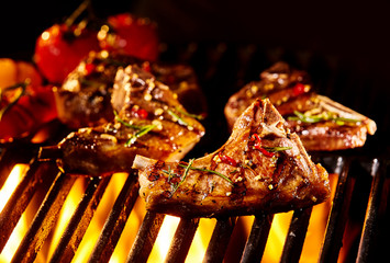 Meat lamb cutlet being grilled under flames