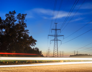 electricity transmission power lines at sunset high voltage tower.