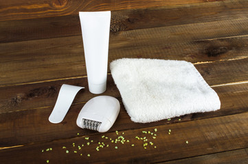 Cream for depilation and spatula to remove. White towel and Electric epilator. On a wooden background.