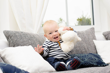 Wall Mural - Kleiner Junge lacht mit seinem Teddy