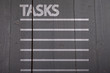 Tasks list on black wooden background