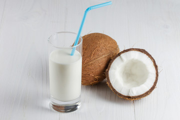 Glass of tasty coconut milk on white table