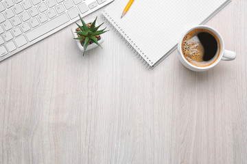 Poster - Cup of coffee with office tools on light wooden background