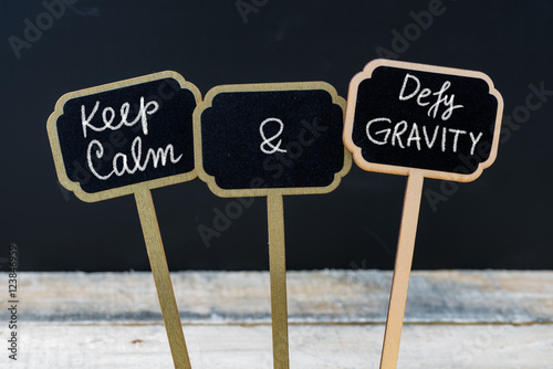 Fotografija Keep Calm and Defy Gravity message written with chalk on mini blackboard labels