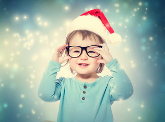 Wall Mural - Toddler girl with Santa hat wearing glasses