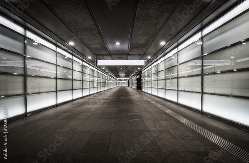 Fotografie, Tablou Empty corridor at night with glass illuminated walls