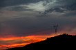 © Manu Reyes - Anochecer rojo/ Anochecer con cielos rojos y azules sobre montañas y torres de alta tensión.