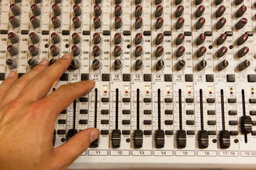 Professional audio mixing console with faders and adjusting knobs