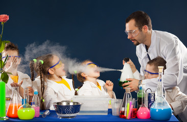 Happy kids with scientist doing science experiments in the laboratory