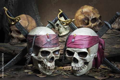 Two Pirate skull over three human skull in the forest