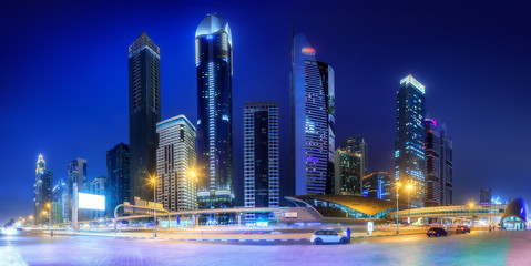 Wall Mural - Panoramic view of metro station and road in Financial district at night, Dubai, UAE