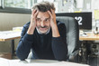 © Westend61 - Mature man sitting in office with head in hands