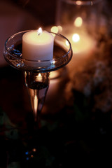 Wall Mural - A look from above on a tiny candle burning over the daisy wreath