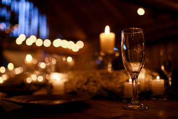 Lonely glass stands behind an empty plate on the dinner table fu