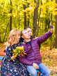 © satura_ - family, childhood, season, technology and people concept - happy family photographing in autumn park