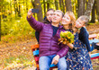 © satura_ - family, childhood, season, technology and people concept - happy family photographing in autumn park