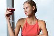 © Mangostar - Smiling Young Woman Raising Glass with Cocktail