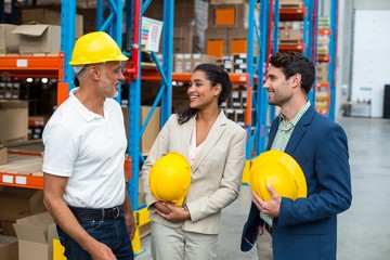 Happy warehouse managers and worker standing together