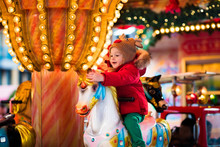 Child Riding Carousel On Christmas Market