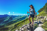 Fototapeta Las - Fit healthy young woman trekking in the Alps