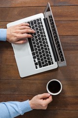 Poster - Man using laptop while having cup of coffee