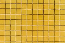 A Wall Surface With Small Yellow Tiles