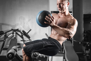 Handsome athletic fitness man posing and trains in the gym.