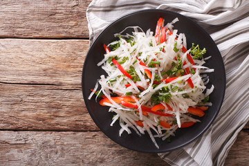 Wall Mural - Fresh salad of daikon with pepper and herbs closeup. horizontal top view