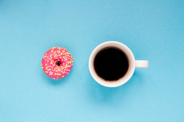 Pink donut with cup of coffee on the blue background.