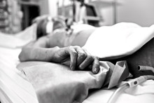 Hand Extremely Exhausted Patients Dying In A Hospital Bed. Black