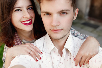 Wall Mural - happy stylish couple taking selfie and smiling at old european c