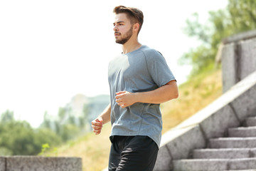 Wall Mural - Young man running on stairs outdoors